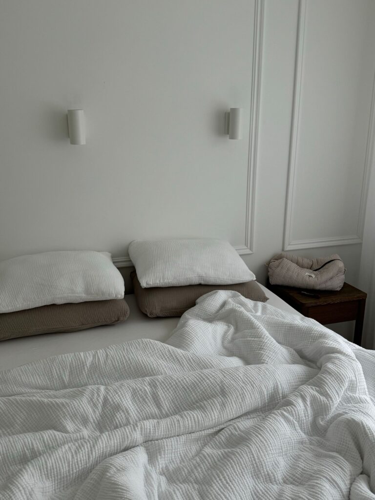 Cozy and inviting minimalist white bedroom with crumpled bedding.